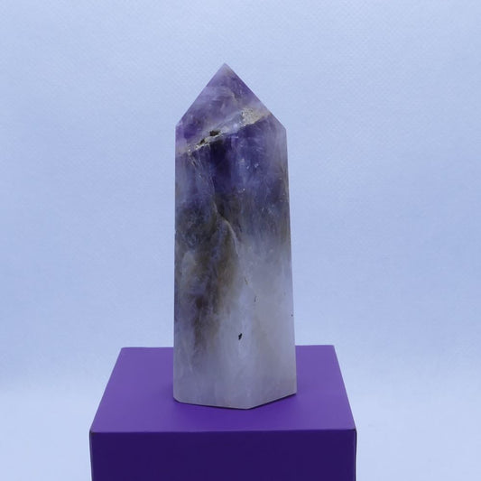 purple amethyst, brown smoky quartz and white quartz healing crystals tower on a purple box and white background, seller dumi's crystals