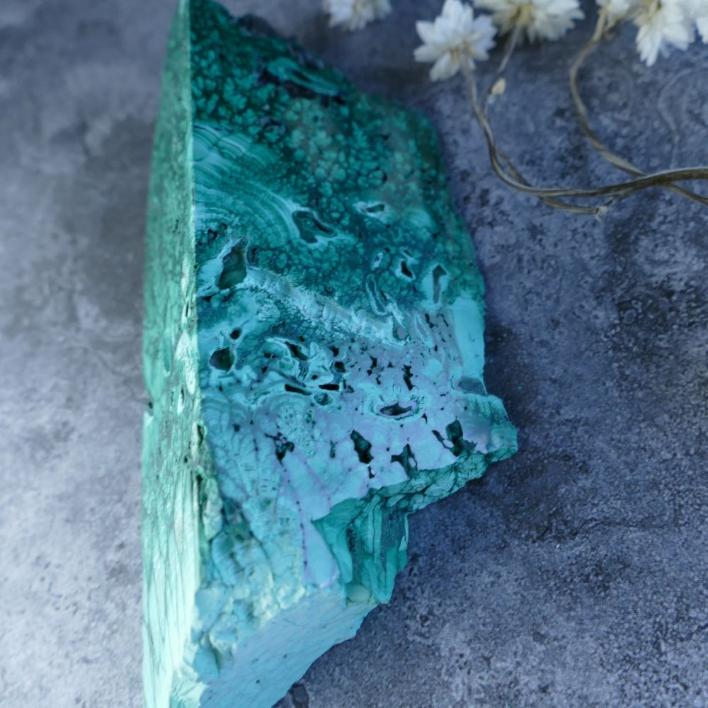 Embrace Change with Dumi's Crystals Malachite Prism (11cm, 3.5cm, 4.3cm, 5.5cm sides). Unpolished malachite reveals raw beauty in a unique triangular form. Promotes healing, protection, and spiritual growth.