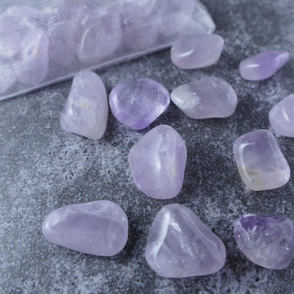 Dumi's Crystals | Light Amethyst Chips (1-1.5cm) | Close-up of a collection of genuine Light Amethyst chips, highlighting their soft lavender color and variations in texture. Light Amethyst is revered for its ability to promote inner peace, focus, and creative inspiration.
