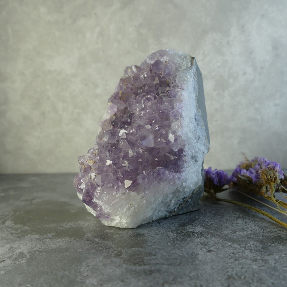 Dumi's Crystals | Lavender Amethyst Cluster (8.9 x 6.3 x 6.3cm) | A Lavender Amethyst Cluster displayed in a living room, radiating a calming energy and creating a tranquil space. This crystal is believed to enhance intuition and spiritual awareness.