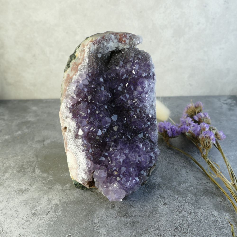 A stunning amethyst cluster from Dumi's Crystals. This captivating piece measures approximately 4.2 inches (10.6cm) tall, 2.5 inches (6.3cm) wide, and 2.7 inches (6.9cm) long, and weighs approximately 605 grams.