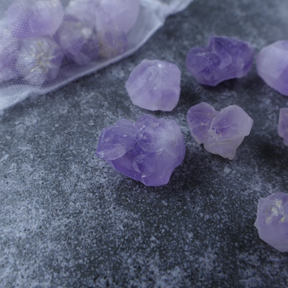 Close-up view of Amethyst Flower chips. These genuine Amethyst crystals boast beautiful purple hues and natural floral patterns, promoting peace, intuition, and spiritual awakening.