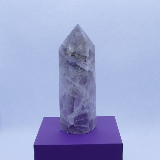 purple amethyst and white quartz healing crystals tower on a purple box and white background, seller dumi's crystals