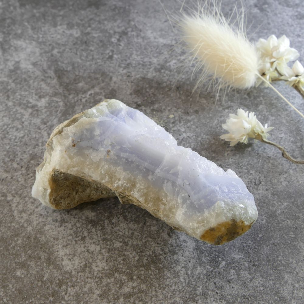 Angled view of a blue lace agate and quartz specimen, demonstrating the natural combination of banded blue stone and sparkling crystal points. Emphasizes the raw, unpolished aesthetic.