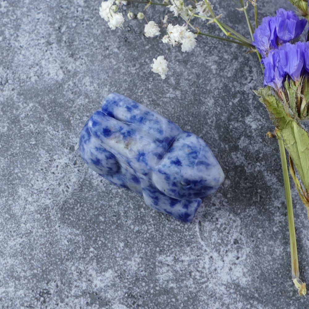 Dumi's Crystals | Blue Spot Jasper Bunny Carving (Creative Spirit):  A Blue Spot Jasper Crystal Bunny Carving, bursting with creative energy. Blue Spot Jasper, the "Stone of Tranquility," promotes emotional balance & clear communication. This bunny fosters creativity & a deeper connection to your inner wisdom. Ethically sourced crystals from Dumi's Crystals.