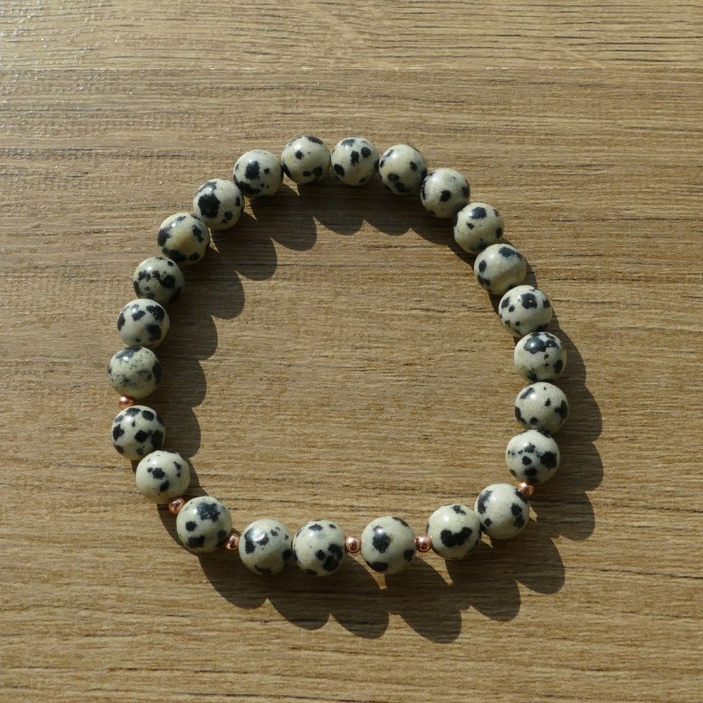 image of an handmade bracelet made with 6mm round dalmatian beads and rose gold 2mm spacer beads. this bracelet is available at dumi's crystals