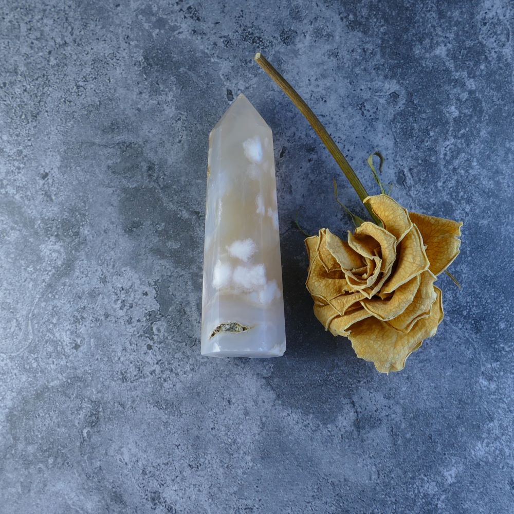 Dumi's Crystals - Unique Flower Agate. This 8.4cm tall, 2.4cm wide agate gemstone boasts a beautiful display of floral inclusions and weighs approximately 72 grams.