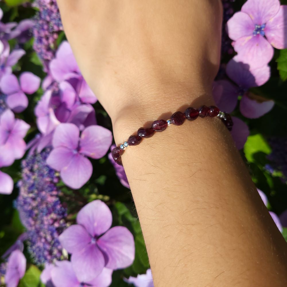 image of a bracelet made with garnet nuggets and silver plated beads. this bracelet is available at dumi's crystals