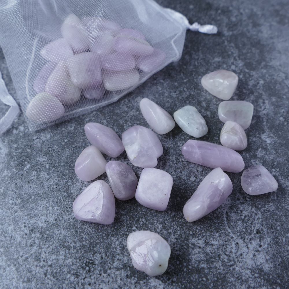 Dumi's Crystals | Kunzite Chips (1-2.5cm) | Close-up of a collection of genuine Kunzite chips, highlighting their captivating pink color and variations in size and texture. Kunzite is revered for its ability to promote love, emotional healing, and inner peace.