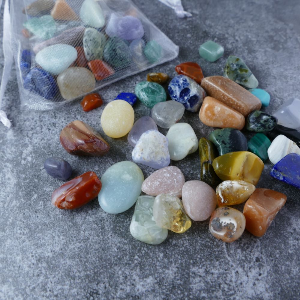 Close-up view of Dumi's Crystals pouch filled with mixed crystal chips. These genuine crystals promote stress relief, balance, and inner peace.