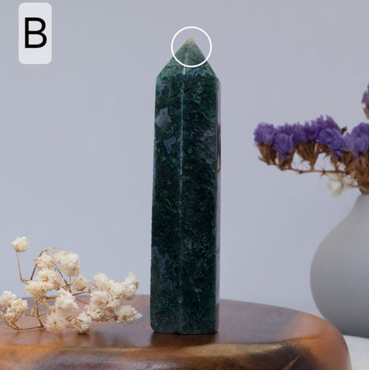 moss agate tower on a wooden surface with a blurred background