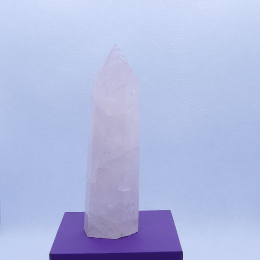 pink rose quartz healing crystals tower on a purple box and white background from dumi's crystals
