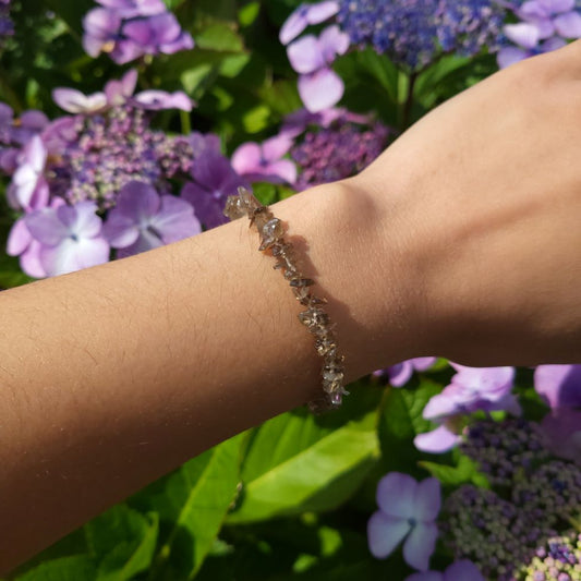 Dumi's Crystals | Smoky Quartz Chip Stretch Bracelet (7 Inch) | Showcasing the captivating beauty of Smoky Quartz chips on a wrist. This bracelet promotes grounding, protection, emotional healing, and mental clarity. Smoky Quartz, the grounding stone, is known for its deep, earthy hues.