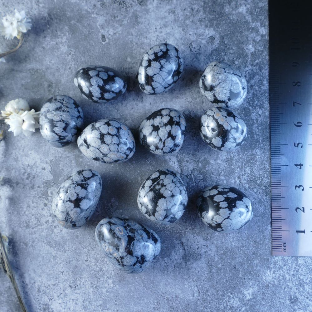Dumi's Crystals - Snowflake Obsidian Tumbled Stones - Find strength and clarity! These mesmerizing black stones (1.5-2.5cm) with white snowflake patterns promote balance and protection (5-10g or 10-15g).