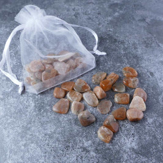 Dumi's Crystals | Sunstone Chips Pouch (20g) | A luxurious organza pouch overflowing with Sunstone chips, showcasing their warm golden hues and variations in size. Sunstone is known for its ability to promote positivity, abundance, and inner joy.
