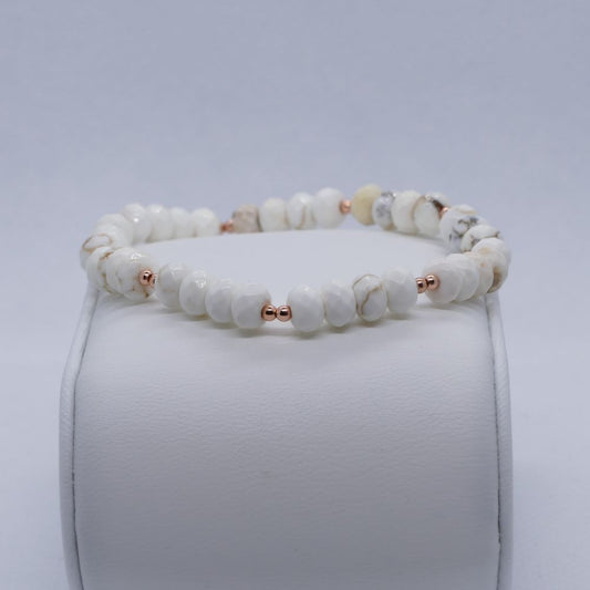 image of a bracelet made with white magnesite rondelles and rose gold beads. this bracelet is available at dumi's crystals