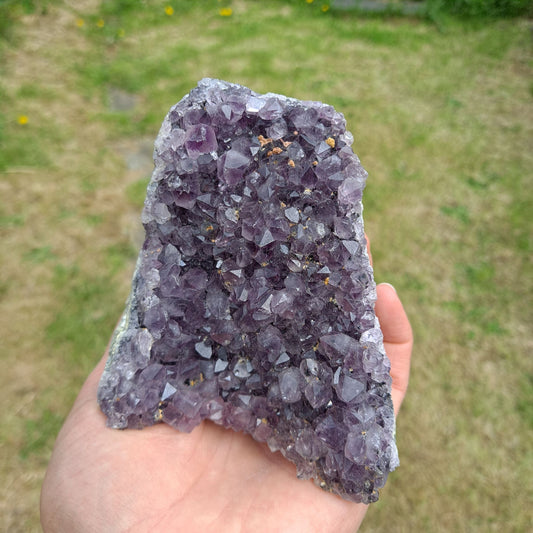 Dumi's Crystals | Amethyst Cluster (Portable, 8.9cm) held in hand | Hold the calming energy of Amethyst close. This Amethyst Cluster (8.9 x 6.3 x 8.9cm) is perfectly sized for holding during meditation or carrying with you throughout the day to promote peace and focus.