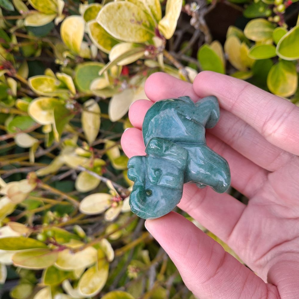 Dumi's Crystals | Green Aventurine Elephant Carving (Empowering Aura): A captivating close-up of a Green Aventurine Elephant Carving, showcasing its intricate details and mesmerizing green hues. Hand-carved from Green Aventurine, this symbol of strength & prosperity radiates empowering energy. Embrace abundance & emotional balance with Dumi's Crystals.