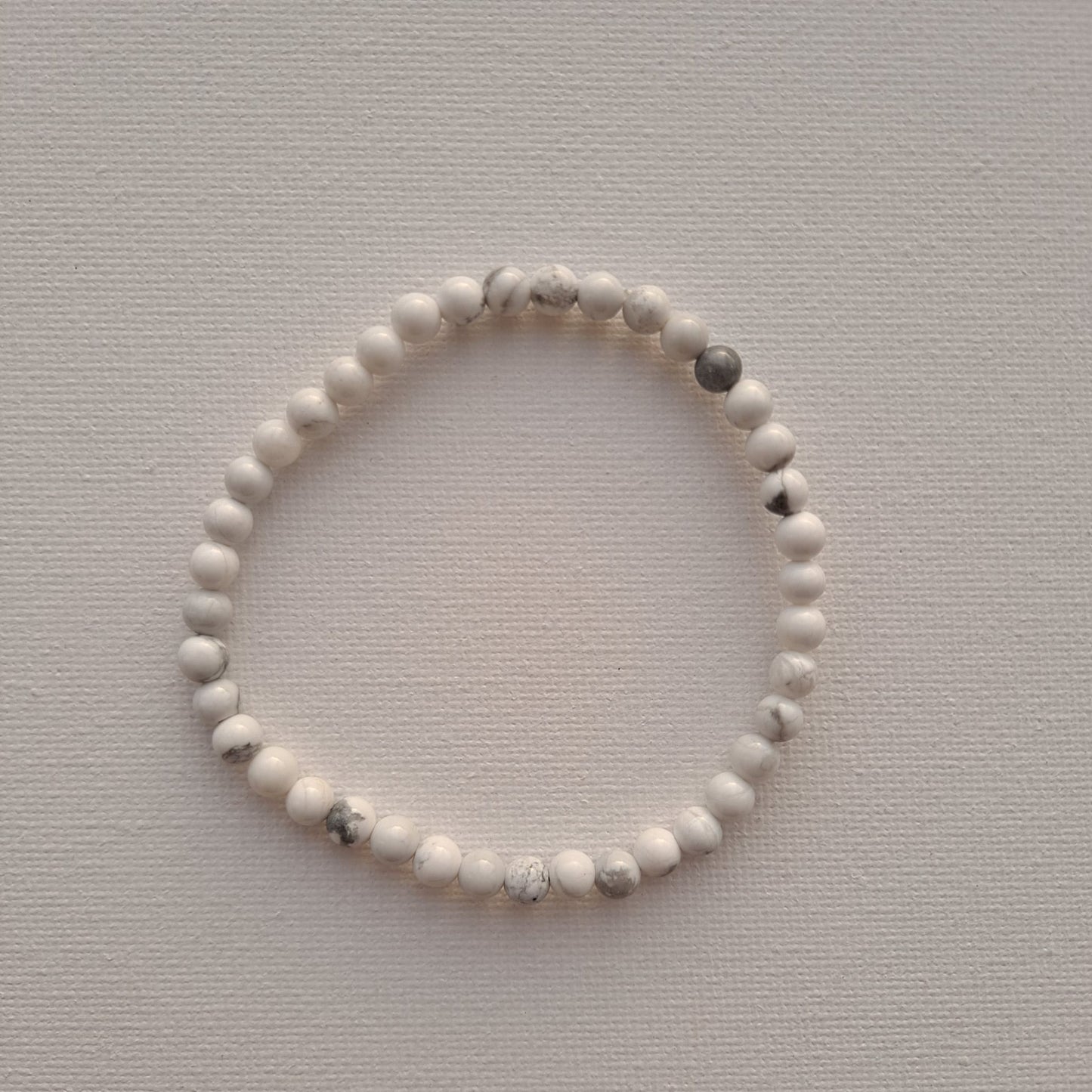 Dumi's Crystals | Howlite Stretch Bracelet (4mm beads) | Close-up of a handcrafted bracelet featuring genuine Howlite beads. The calming white color of Howlite, often called the "stone of calmness," is believed to promote stress relief, mental clarity, and emotional balance.