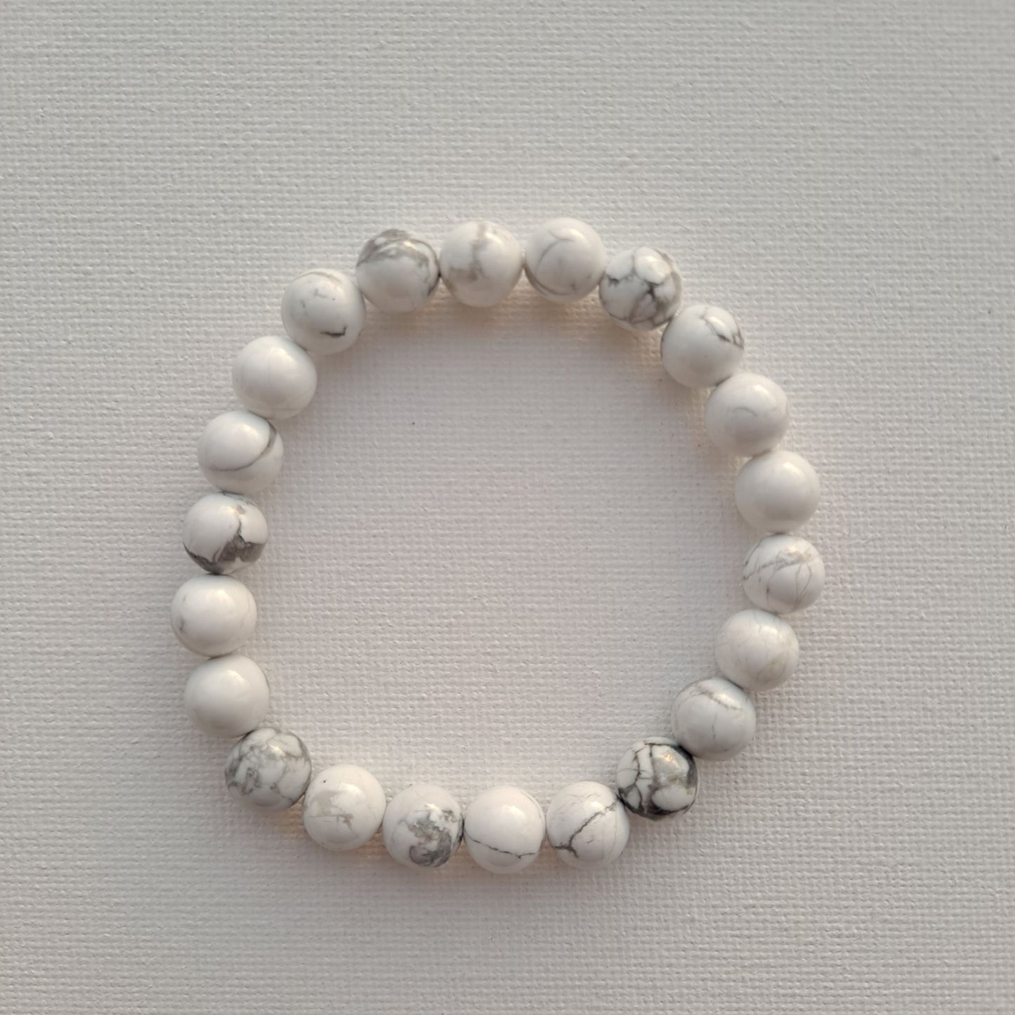 Dumi's Crystals | Howlite Stretch Bracelet (8mm beads) | Close-up of a handcrafted bracelet featuring genuine Howlite beads, each measuring 8mm for a bolder statement piece. The calming white color of Howlite, often called the "stone of calmness," is believed to promote stress relief, mental clarity, and emotional balance.