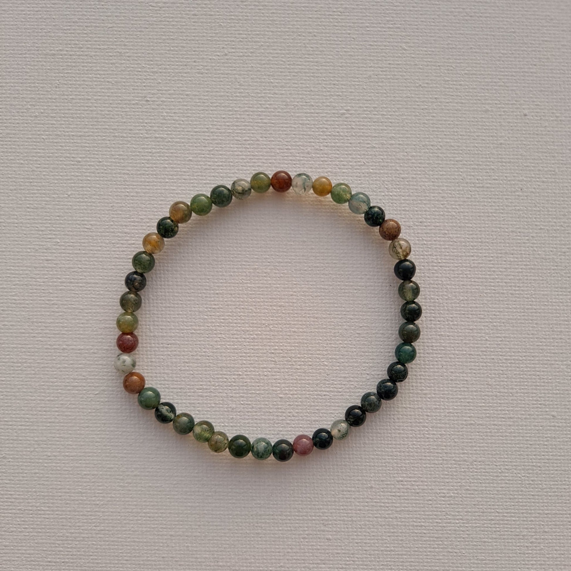 Dumi's Crystals | Indian Agate Stretch Bracelet (4mm) | Close-up of a handcrafted bracelet featuring genuine Indian Agate beads. The captivating variety of colours and swirling patterns promote emotional stability, focus, and creativity. Often called the "Earth Rainbow Stone."