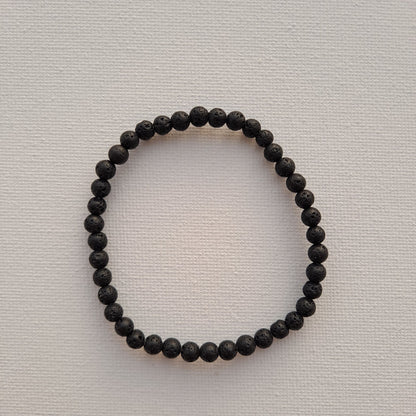 Dumi's Crystals | Lava Stone Stretch Bracelet (4mm) | Close-up of a handcrafted bracelet featuring genuine 4mm Lava Stone beads. The porous volcanic rock is known for its grounding energy and can be used as a diffuser for essential oils.