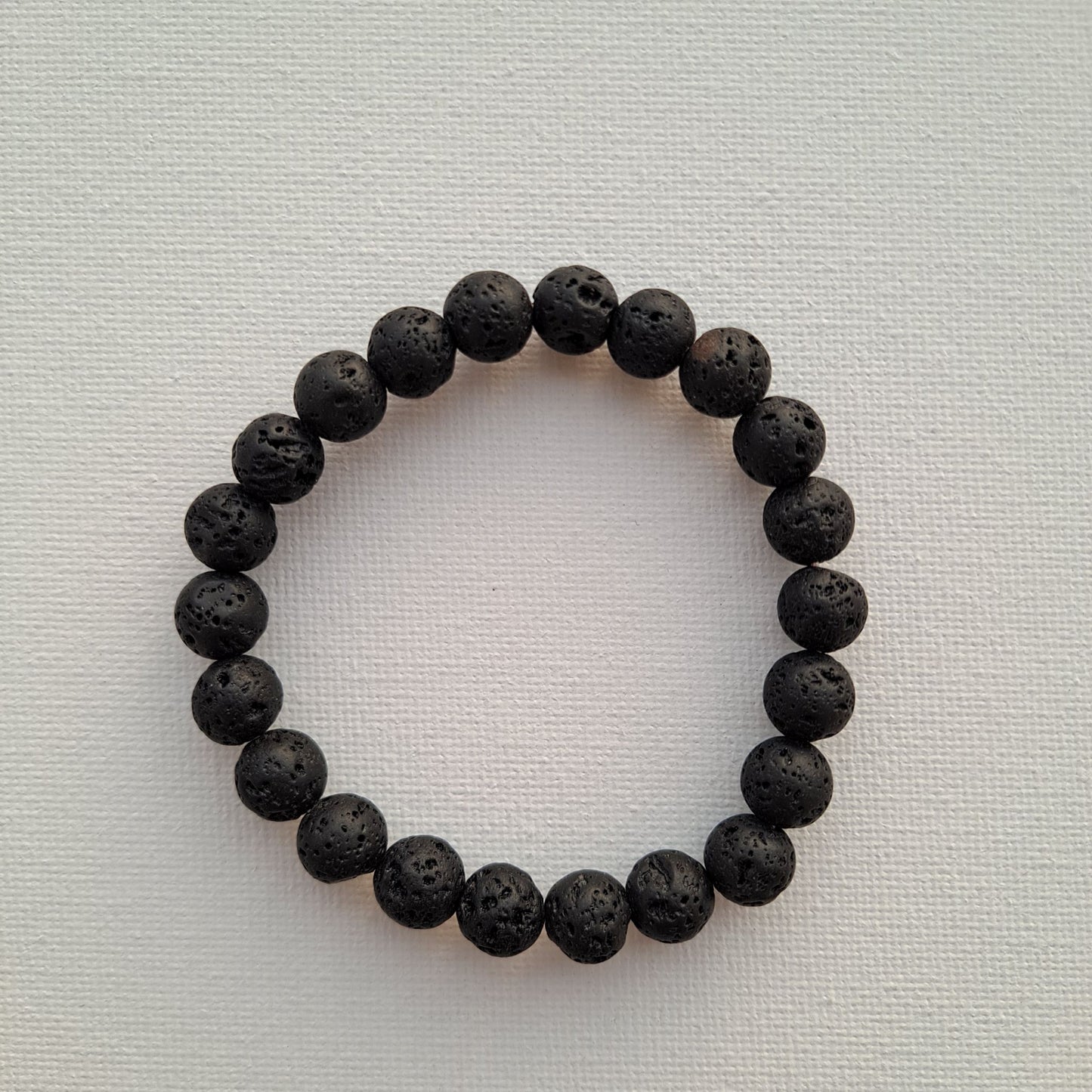 Dumi's Crystals | Lava Stone Stretch Bracelet (8mm) | Close-up of a handcrafted bracelet featuring genuine 8mm Lava Stone beads. Known for their grounding energy, these porous volcanic rock beads can also be used to diffuse your favourite essential oils.