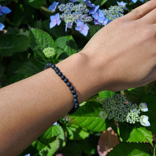 Dumi's Crystals | Lava Stone Stretch Bracelet (4mm) | Showcasing the sleek black beauty of 4mm Lava Stone beads on a wrist. This bracelet offers grounding energy, aromatherapy benefits, and a stylish touch.