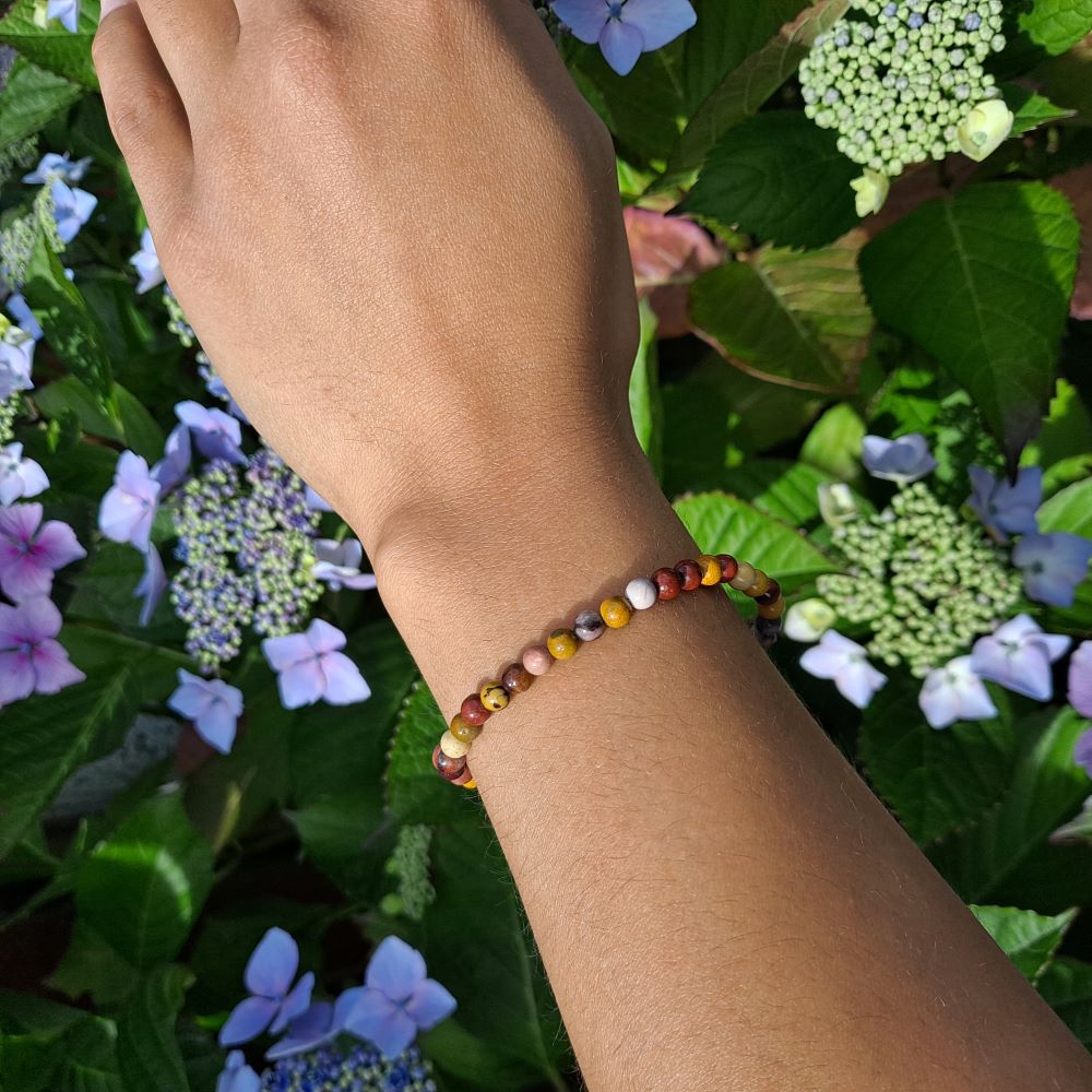 Dumi's Crystals | 4mm Mookaite Jasper Stretch Bracelet | Showcasing the delicate beauty of 4mm Mookaite Jasper beads on a wrist. This bracelet offers grounding energy, emotional balance, and a connection to nature's beauty.