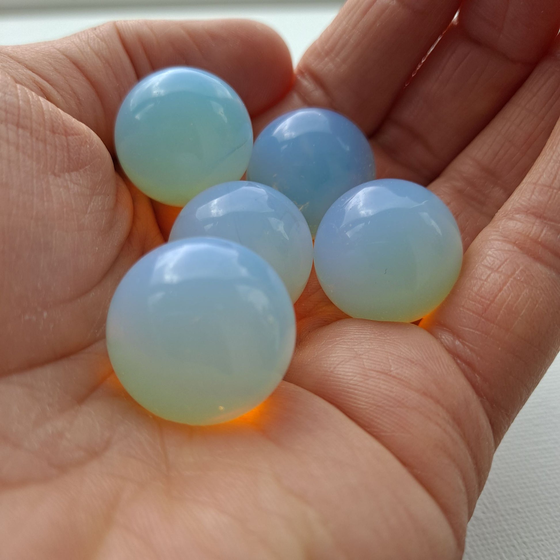  Dumi's Crystals | Opalite Mini Spheres (20mm) | A collection of captivating Opalite Mini Spheres, each displaying a unique variation of color. These 20mm, man-made spheres are believed to promote peace, tranquility, and inner strength. Perfect for meditation, crystal grids, or carrying with you throughout the day.