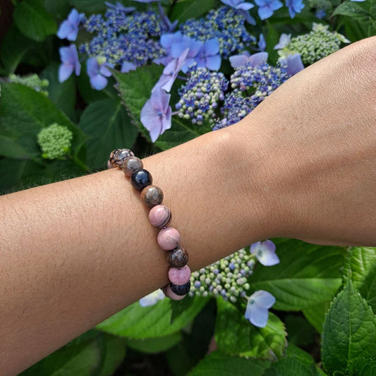 Bold 8mm Rhodonite bracelet for love and compassion on wrist | Dumi's Crystals | Embrace strength & inner peace with this Rhodonite stretch bracelet. Rich pink tones, promotes emotional balance and strong relationships.