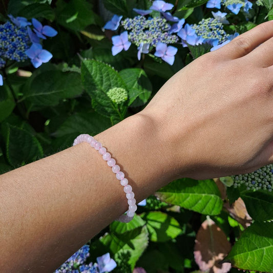 Dumi's Crystals | 4mm Rose Quartz Stretch Bracelet (7 Inch) | Showcasing the delicate beauty of 4mm Rose Quartz beads on a wrist. This bracelet promotes emotional healing, self-love, and fosters compassion. Rose Quartz, the stone of unconditional love, is known for its soft pink hues.