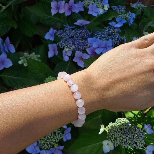 Dumi's Crystals | 8mm Rose Quartz Stretch Bracelet (7 Inch) | Showcasing the captivating beauty of 8mm Rose Quartz beads on a wrist. This bracelet promotes emotional healing, self-love, and fosters confidence. Rose Quartz, the stone of unconditional love, is known for its rich pink hues.