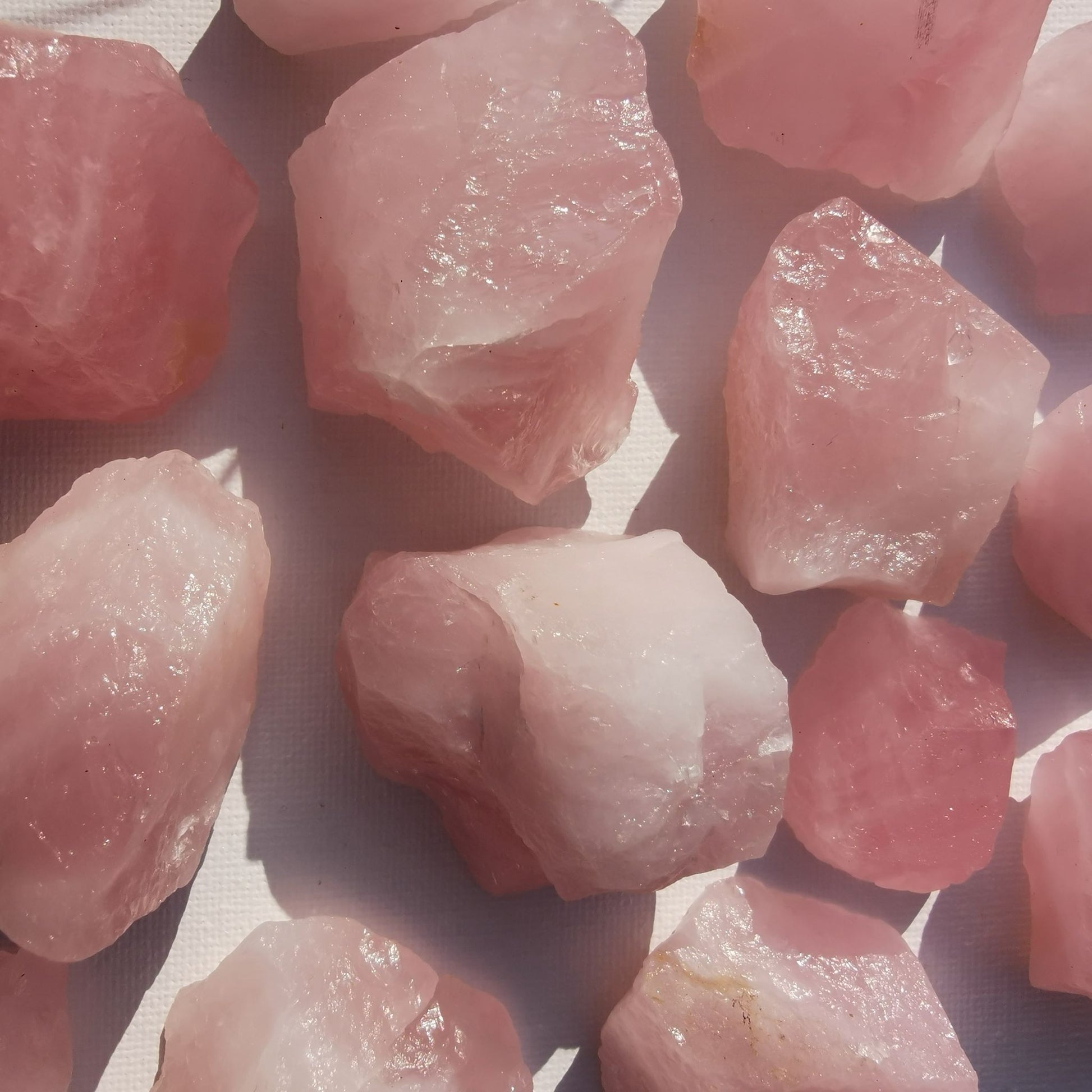 Dumi's Crystals | Rough Rose Quartz Crystals (Growth & Connection) | A collection of Rough Rose Quartz Crystals, reminders of self-love and connection. Rose Quartz fosters love, reduces negativity & strengthens bonds. Scatter them in your home or bedroom to create a loving environment, promote emotional healing & welcome deeper connections. Embrace the power of Rough Rose Quartz from Dumi's Crystals!