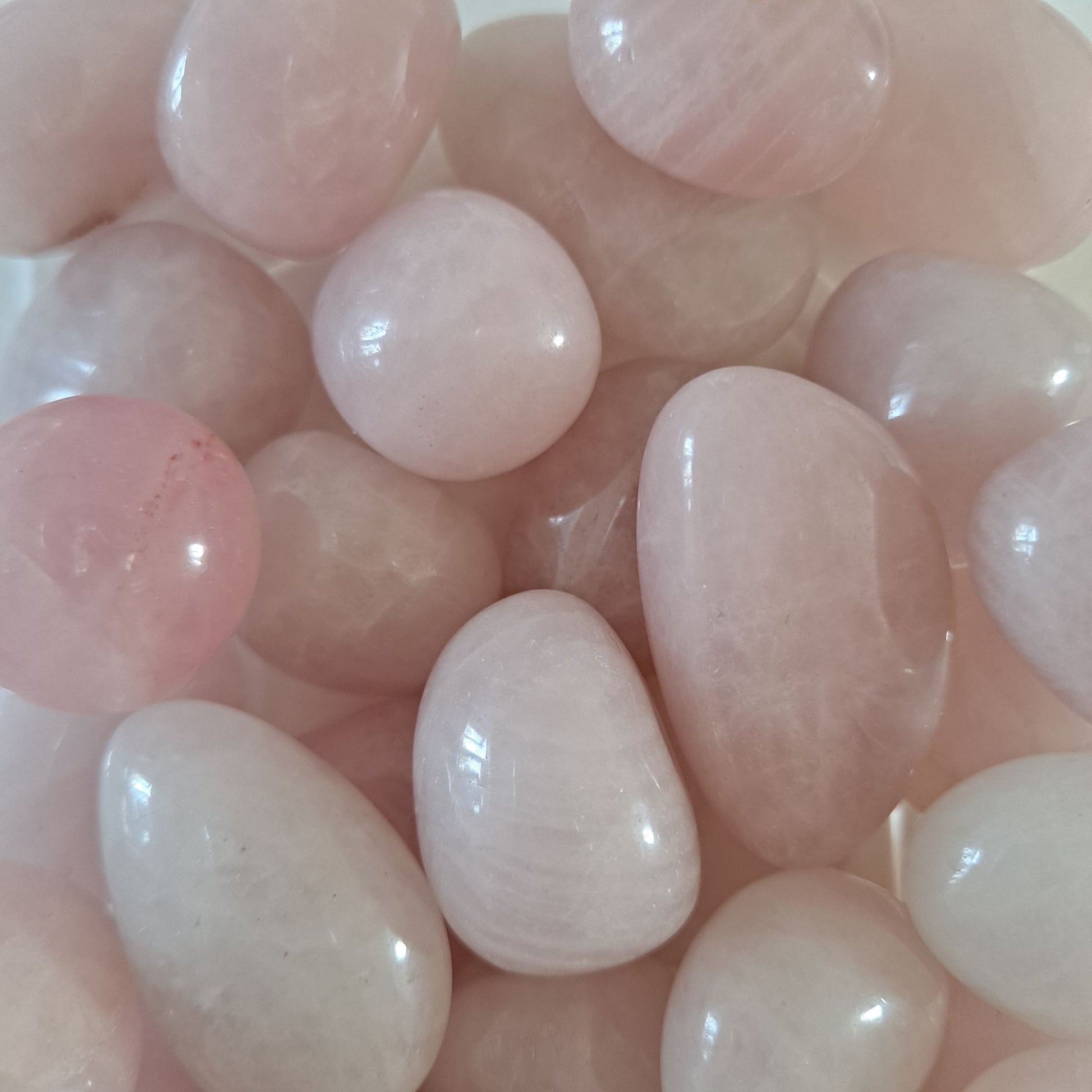 Dumi's Crystals | Rose Quartz Tumbled Stones (Peace & Harmony) | A collection of Rose Quartz Tumbled Stones, reminders of the love within. Rose Quartz fosters compassion, reduces anxiety & promotes inner peace. Scatter them in your home or workspace to create a space overflowing with loving energy and a sense of tranquility. Cultivate a life filled with love and harmony with Rose Quartz.