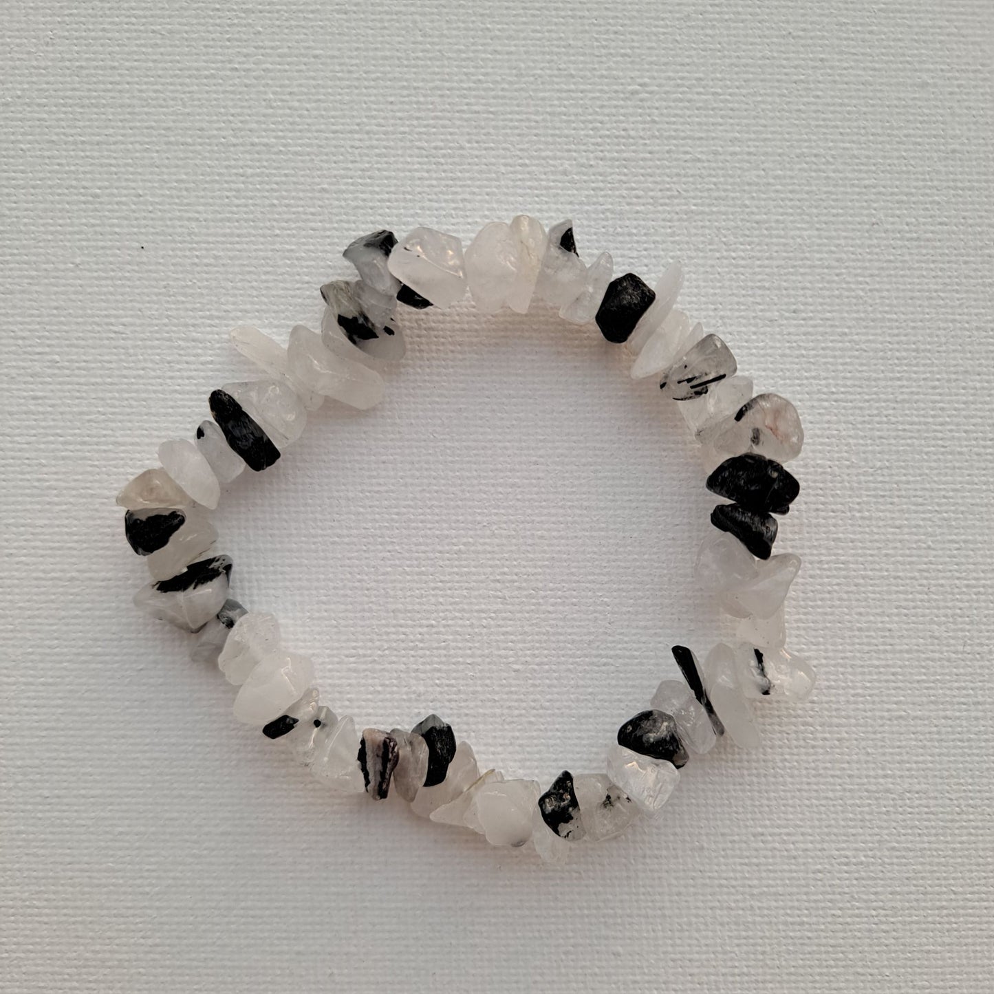 Dumi's Crystals Black Rutilated Quartz Chip Bracelet. Embrace cosmic energy with black rutile & quartz chips. Promotes clarity, intuition & spiritual growth.