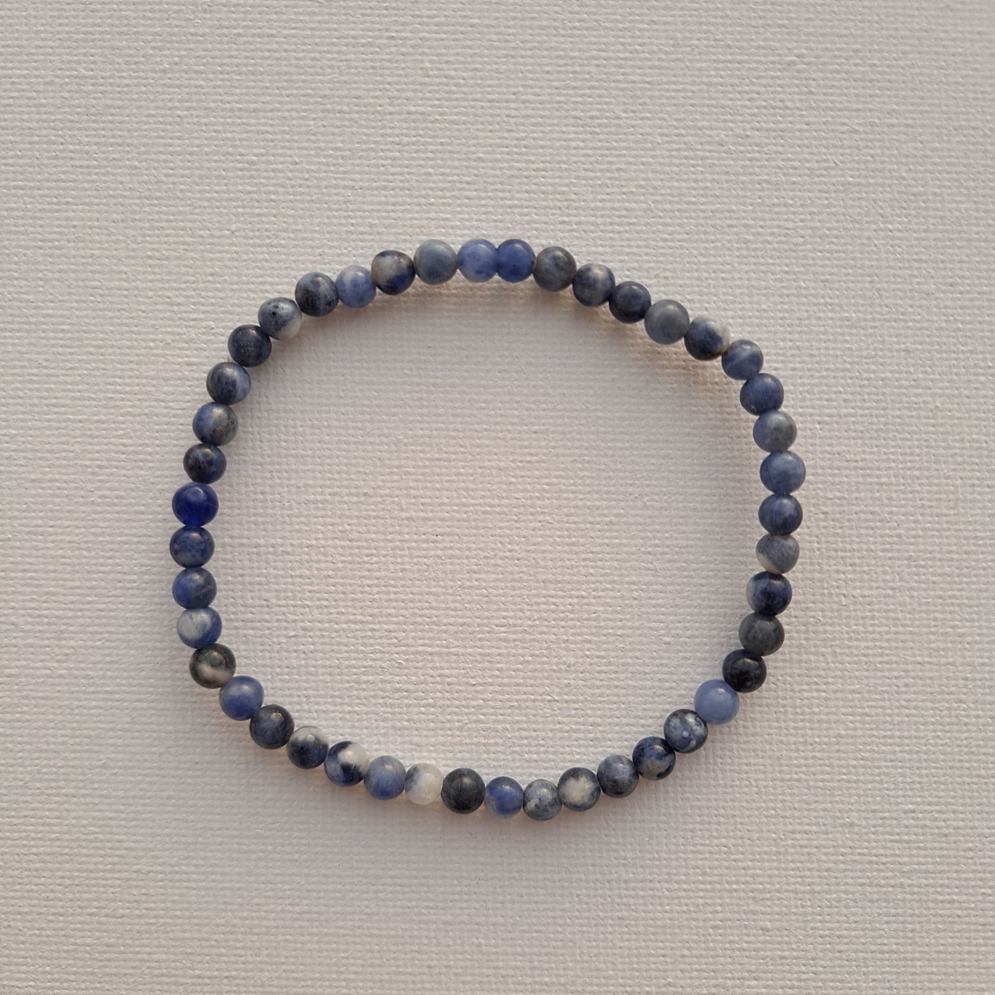 7-Inch Sodalite Stretch Bracelet (4mm Beads) | Dumi's Crystals | Delicate 4mm Sodalite beads strung on a durable stretch cord. This bracelet is believed to promote clear communication, self-expression, inner wisdom, mental clarity, emotional balance, and peace.