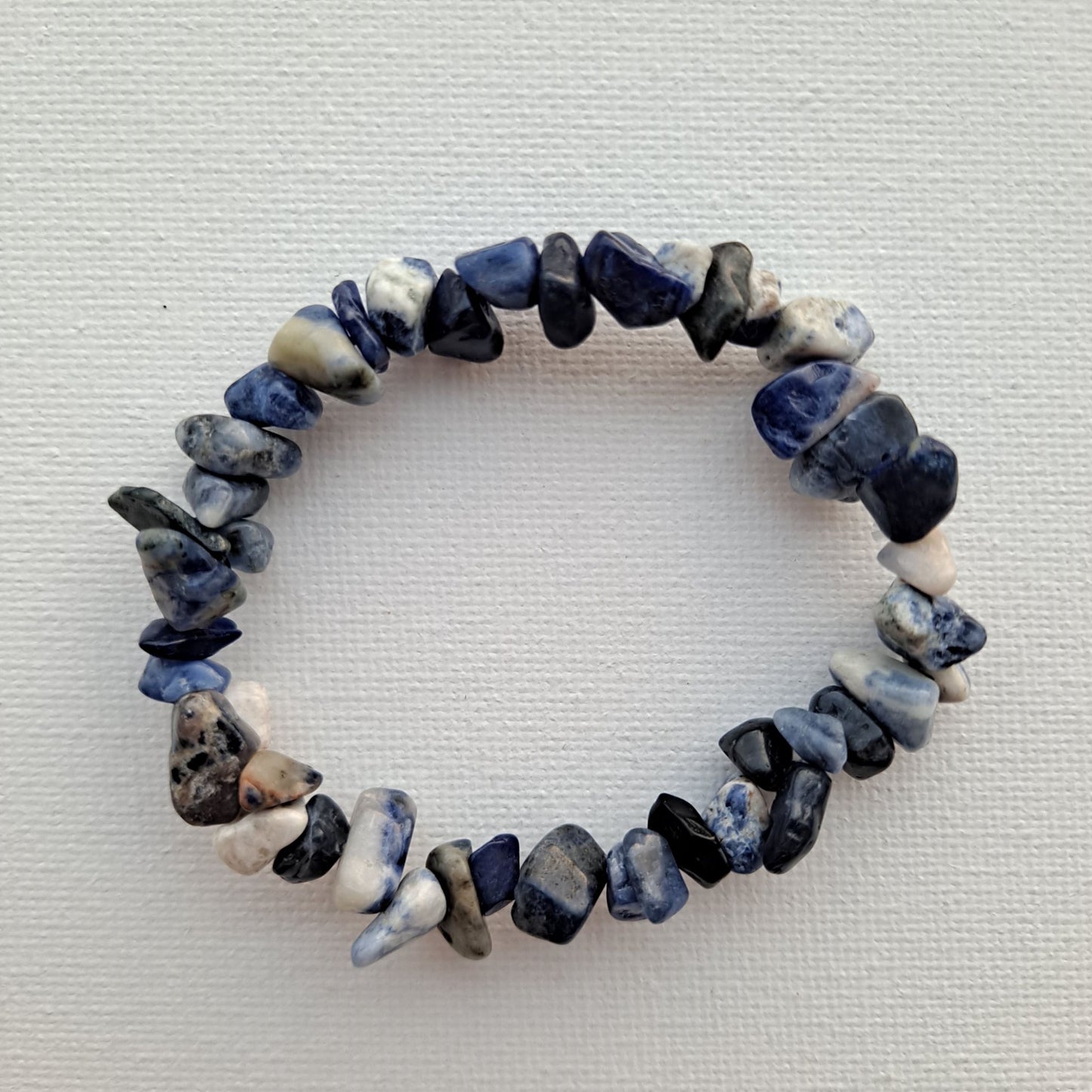 Dumi's Crystals | Sodalite Stretch Bracelet (7 Inch) | Close-up of a handcrafted bracelet featuring genuine sodalite chips in deep blue hues. Sodalite is known as the stone of truth and communication and is believed to promote clear communication, inner wisdom, mental clarity, and emotional balance.