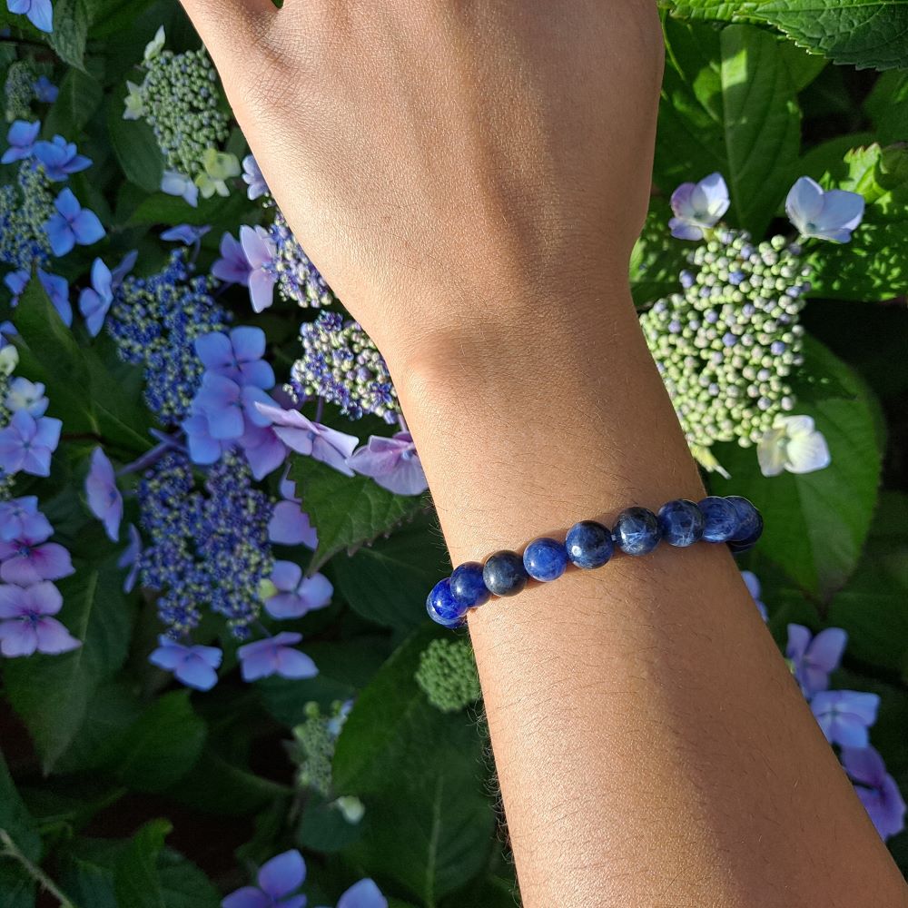 Dumi's Crystals | Sodalite Stretch Bracelet (8mm Beads) (7 Inch) | Showcasing the captivating beauty of 8mm beads on a wrist. This bracelet promotes clear communication, self-expression, inner wisdom, and mental clarity. Sodalite, the stone of truth and communication, is known for its deep blue hues.