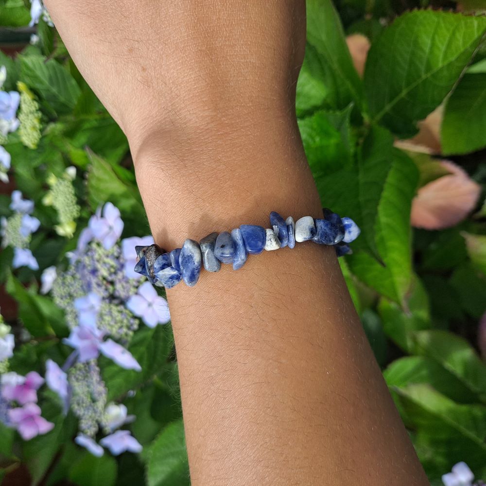 Dumi's Crystals | Sodalite Chip Bracelet (7 Inch) | Showcasing the captivating beauty of sodalite chips on a wrist. This bracelet promotes clear communication, self-expression, inner wisdom, and mental clarity. Sodalite, the stone of truth and communication, is known for its deep blue hues.
