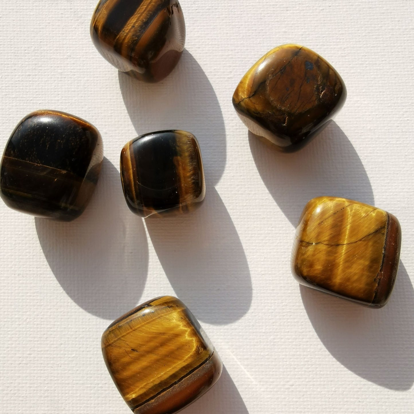 Dumi's Crystals | Square Tiger's Eye Tumbled Stones (Confidence & Success) | A collection of Square Tiger's Eye Tumbled Stones, each a reminder of the tiger's spirit. Square Tiger's Eye fosters strength, reduces stress & attracts success. Scatter them in your home or workspace to create a space overflowing with empowering energy and a sense of purpose.