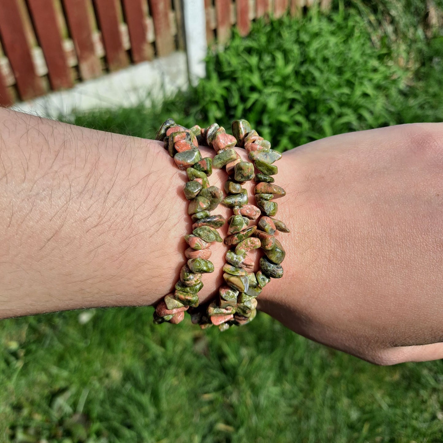 Dumi's Crystals | Unakite Chip Stretch Bracelet (7 Inch) | Close-up of a handcrafted bracelet featuring genuine Unakite chips in a captivating array of calming greens and soft pinks. Unakite is known as the stone of emotional healing and is believed to promote emotional balance, healing past wounds, self-love, and a positive outlook.
