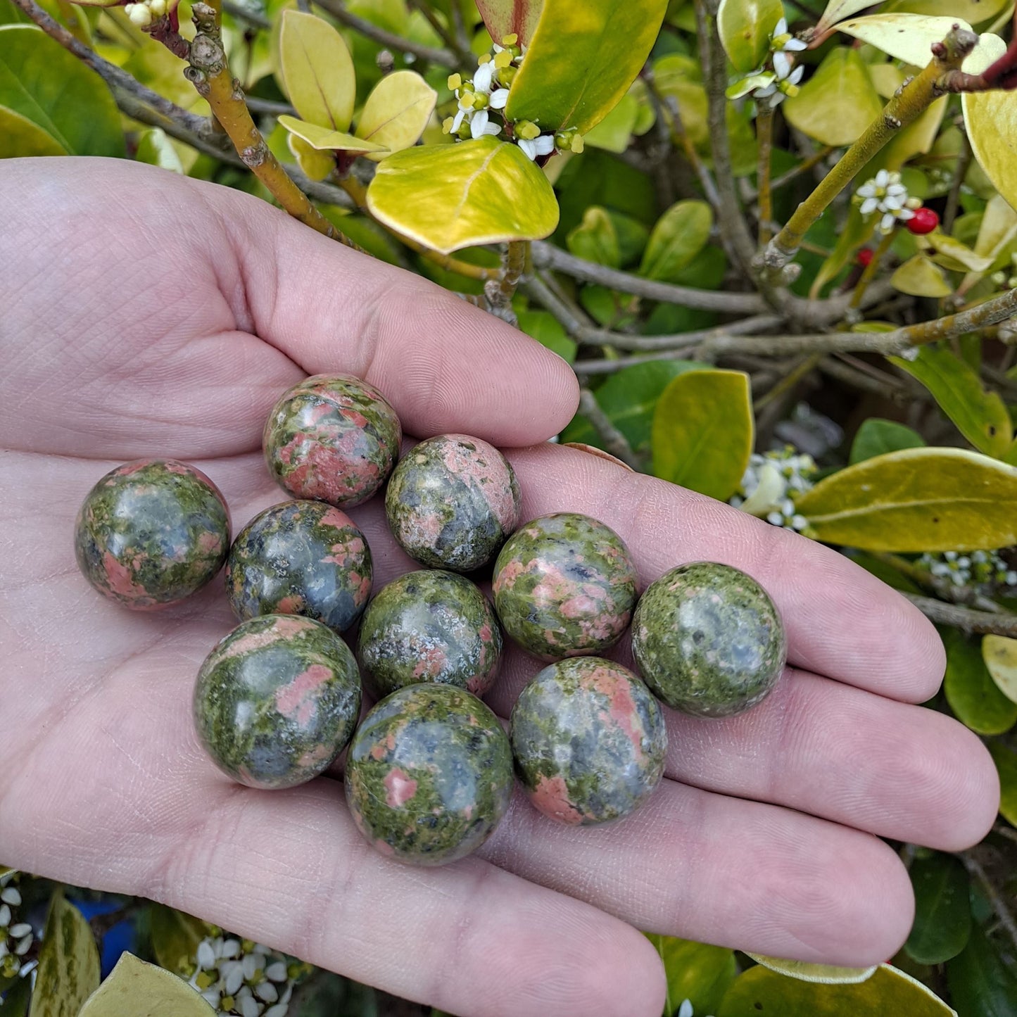 Dumi's Crystals | Unakite Spheres (20mm) | A collection of captivating Unakite Spheres (20mm), each displaying variations in their pink and green hues. These mini spheres offer a striking presence, perfect for meditation, crystal grids, or adorning your altar.