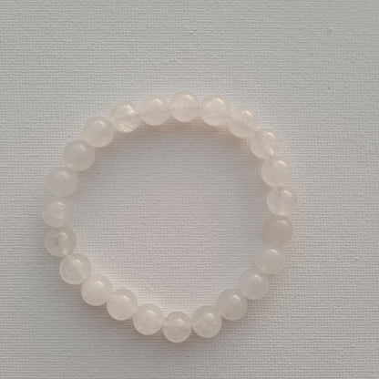 Dumi's Crystals | White Jade Stretch Bracelet (7 Inch with 8mm Beads) | Close-up of a handcrafted bracelet featuring genuine 8mm White Jade beads with a luminous glow. White Jade is known as the stone of peace and tranquility and is believed to promote inner peace, clarity of mind, spiritual growth, and emotional balance.