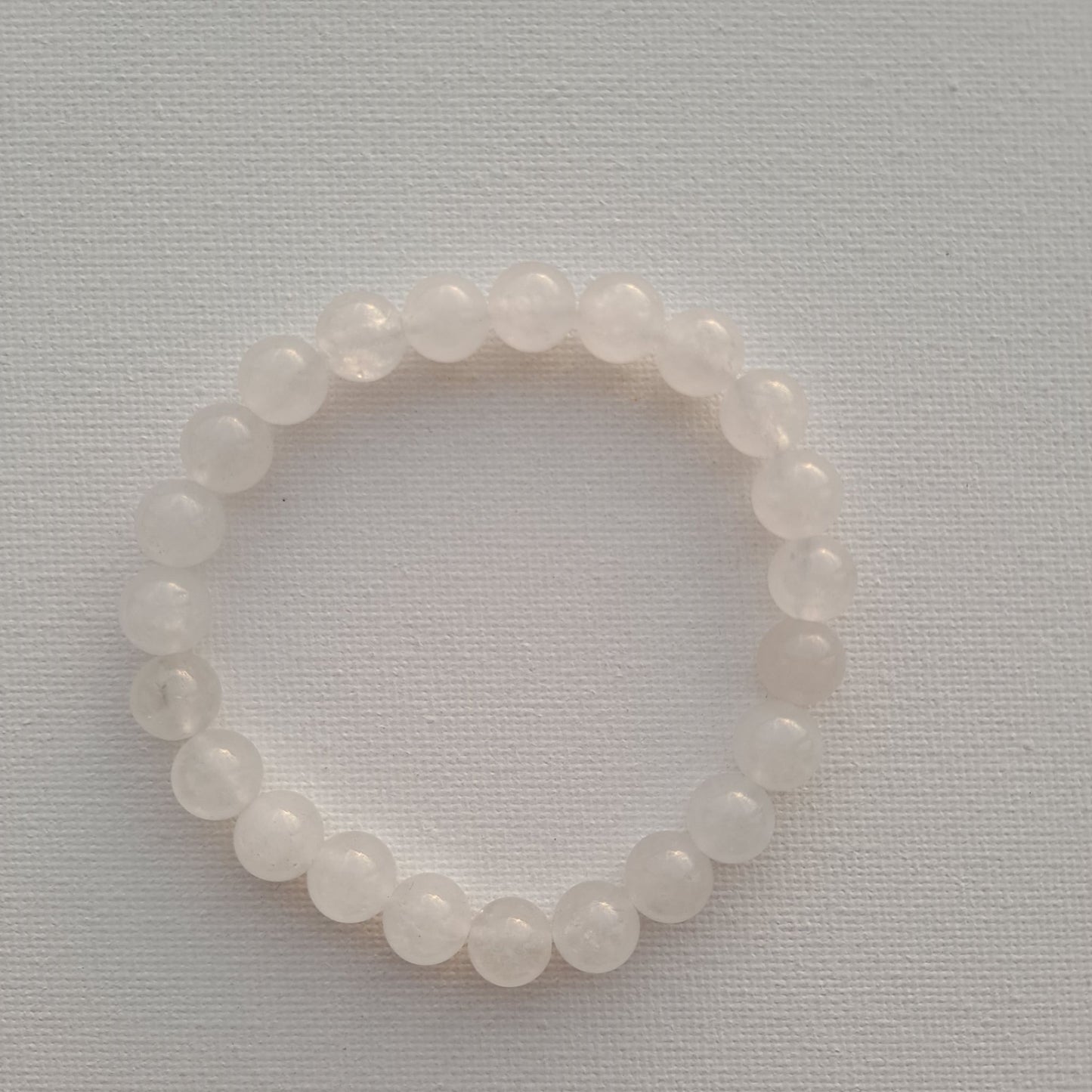 Dumi's Crystals | White quartz Stretch Bracelet (7 Inch with 8mm Beads) | Close-up of a handcrafted bracelet featuring genuine 8mm White quartz beads with a luminous glow.