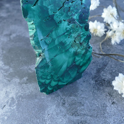 Unleash Malachite's Power in a Unique Form! Dumi's Crystals Triangular Prism (11.5cm, 3cm x 4.5cm x 3cm base). Stunning malachite slab promotes emotional well-being, protection, and spiritual awakening.  