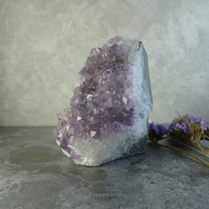 Dumi's Crystals | Lavender Amethyst Cluster (8.9 x 6.3 x 6.3cm) | A Lavender Amethyst Cluster displayed in a living room, radiating a calming energy and creating a tranquil space. This crystal is believed to enhance intuition and spiritual awareness.