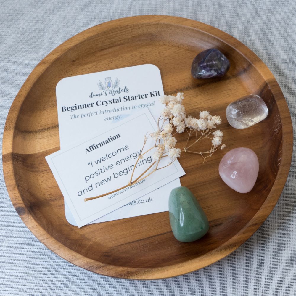 Wooden tray with crystals and a card on a gray background