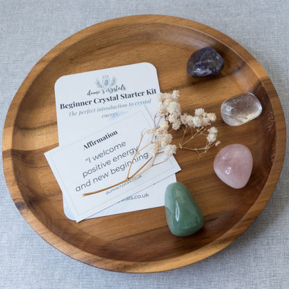 Wooden tray with crystals and a card on a gray background