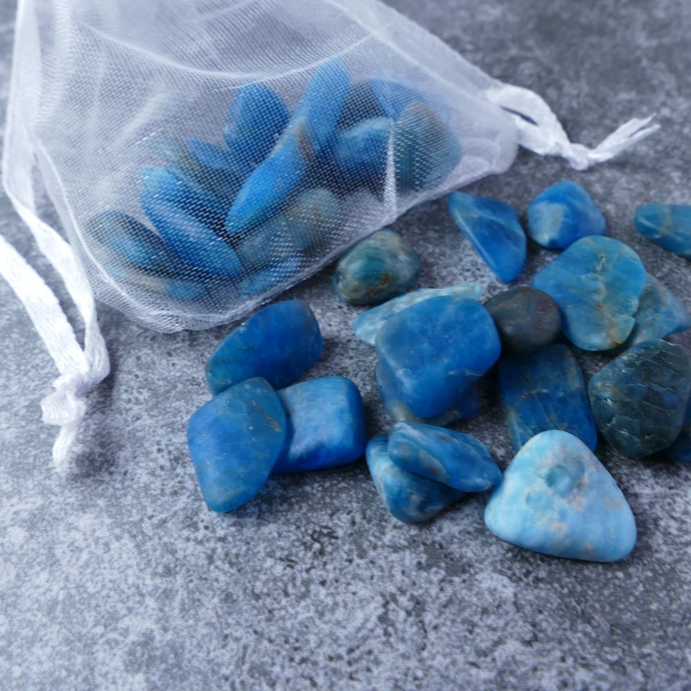 Dumi's Crystals | Blue Apatite Chips (1-3cm) | Close-up of a collection of genuine Blue Apatite chips, highlighting their captivating deep blue color and variations in size and texture. Blue Apatite is revered for its ability to promote manifestation, mental clarity, and creative inspiration.